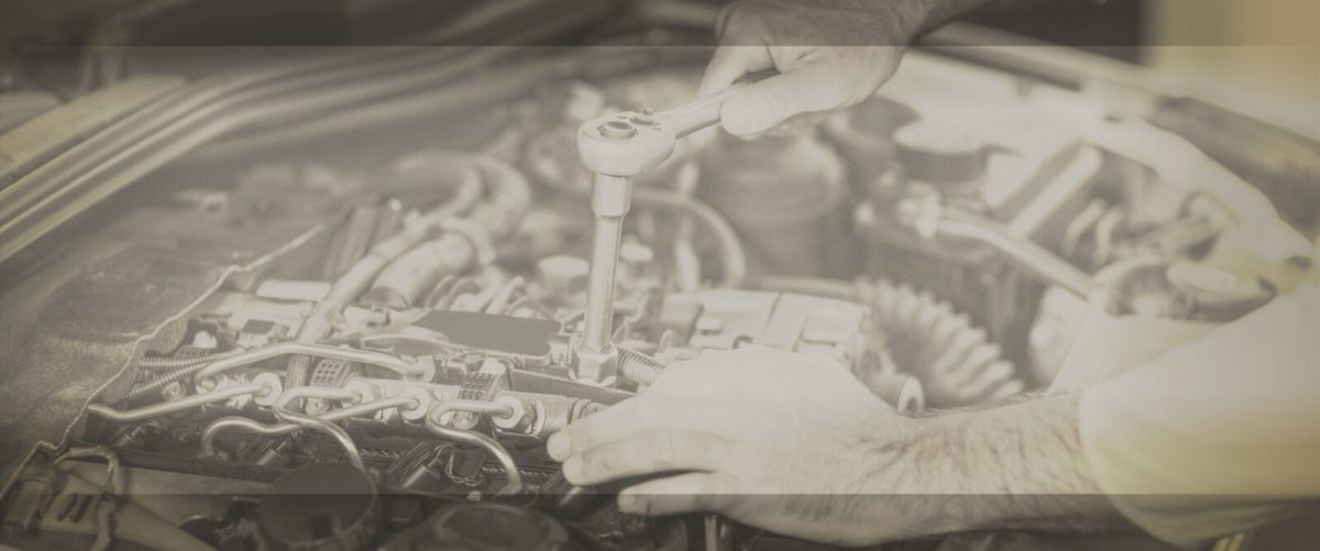 Hands of mechanic servicing a car in repair garage